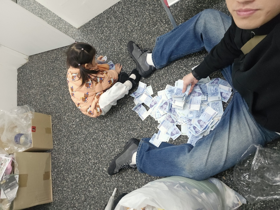 무인매장 바닥에서 아이와 함께 1,000원권 지폐 수입을 정리하는 직장인 창업자의 실제 모습