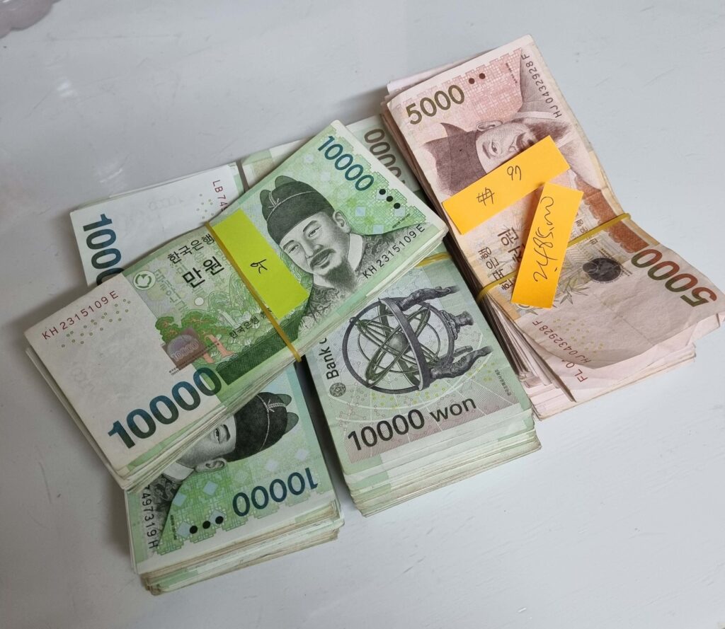 무인사진관 운영을 통해 발생한 현금 매출 뭉치와 노란 포스트잇 정산 기록